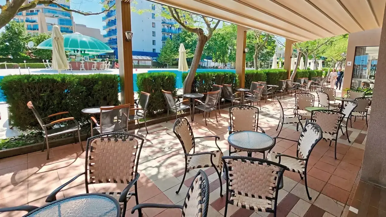 Taras z meblami w Sentido Bellevue Beach  otoczony zielenią