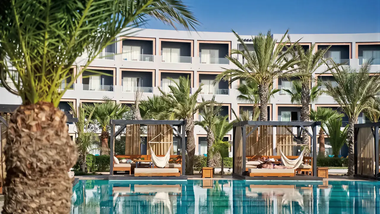 Basen z leżakami i palmami w Sentido Marillia Resort & Spa