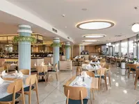 Jasna restauracja z nakrytymi stołami w Sentido Neptun Beach