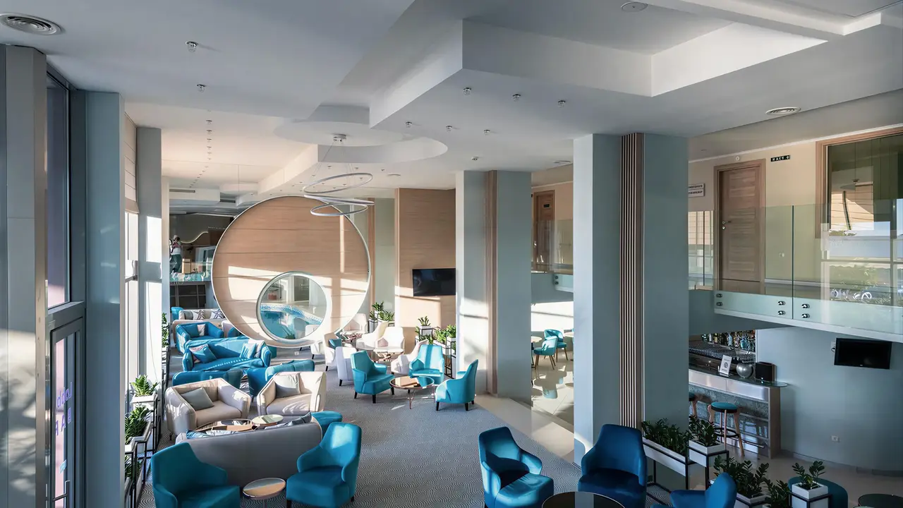 Nowoczesny hol z niebieskimi fotelami w Sentido Neptun Beach
