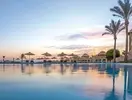 Basen z parasolami w Serenity Alpha Beach o zachodzie słońca