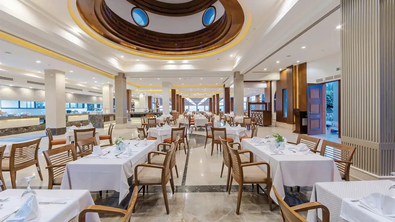 Jasna restauracja z nakrytymi stołami w Serenity Alpha Beach