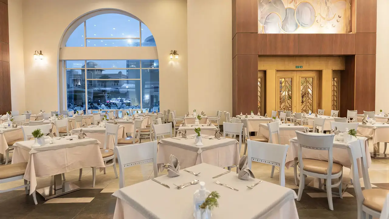 Elegancka restauracja w Serenity Alpha Beach z nakrytymi stołami