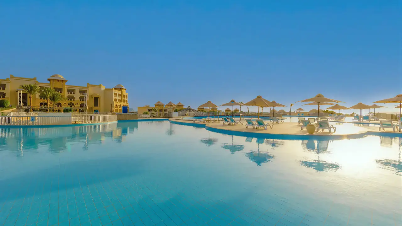 Basen z leżakami i parasolami w Serenity Alpha Beach
