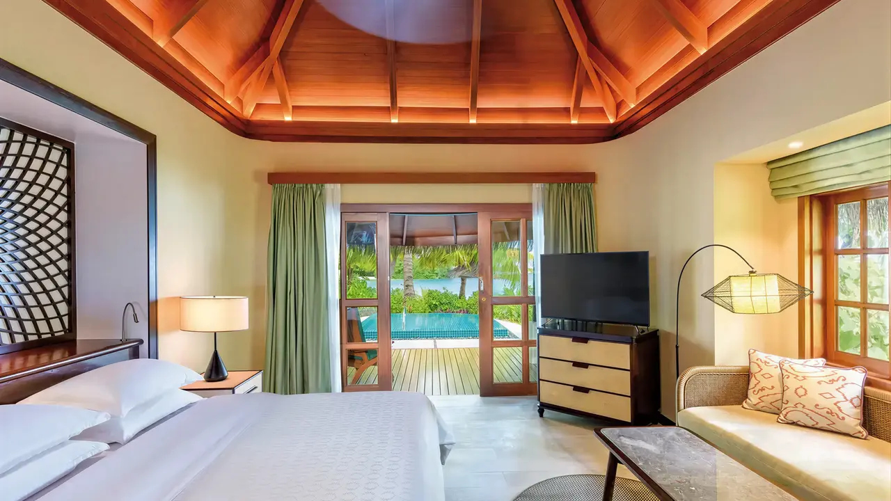 Sypialnia z widokiem na basen w Sheraton Maldives Full Moon Resort & Spa