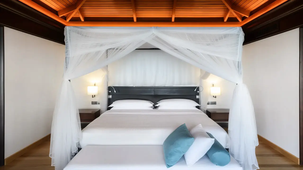 Sypialnia z dużym łóżkiem w Sheraton Maldives Full Moon Resort & Spa