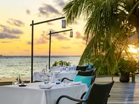 Stół restauracyjny nad morzem w Sheraton Maldives Full Moon Resort & Spa