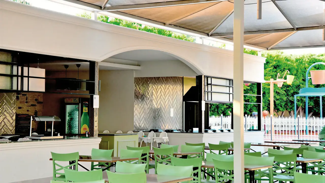 Strefa jadalna z zielonymi krzesłami w Side Mare Resort & Spa