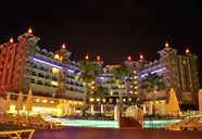 Oświetlony budynek Side Mare Resort & Spa z widokiem na basen