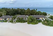 Widok na kompleks Sirru Fen Fushi Private Lagoon Resort przy białej plaży