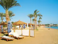 Plaża z leżakami i palmami w Steigenberger Al Dau Beach