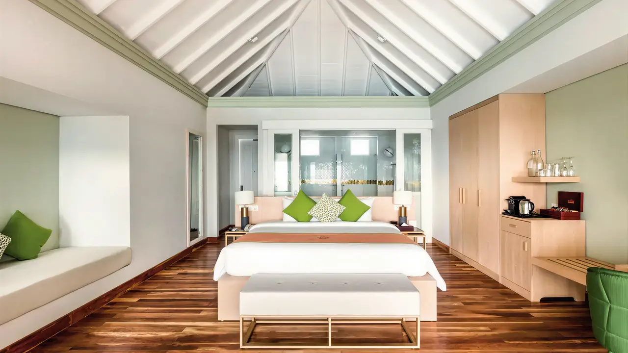 Sypialnia w hotelu Sun Siyam Olhuveli z drewnianą podłogą