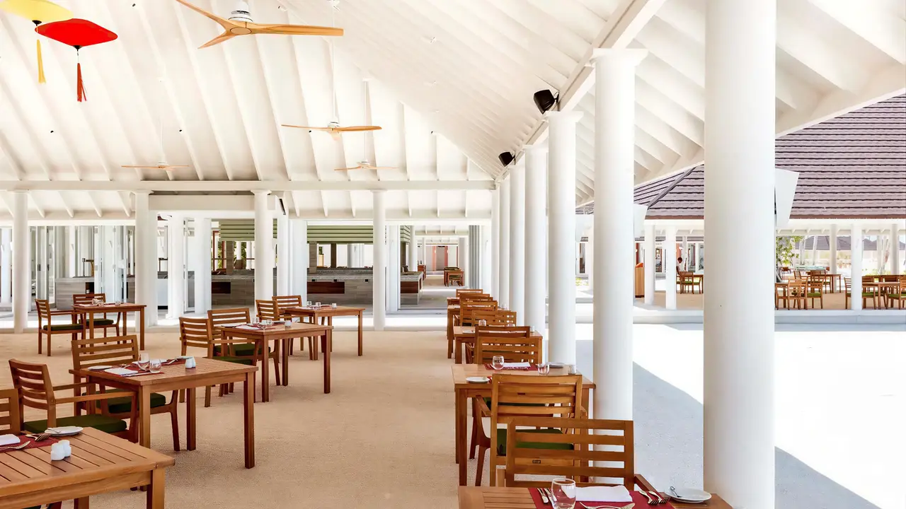 Jasna restauracja w Sun Siyam Olhuveli z drewnianymi stołami