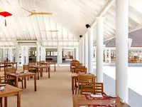 Jasna restauracja w Sun Siyam Olhuveli z drewnianymi stołami