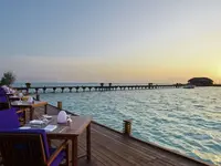 Restauracja nad wodą w Sun Siyam Olhuveli o zachodzie słońca