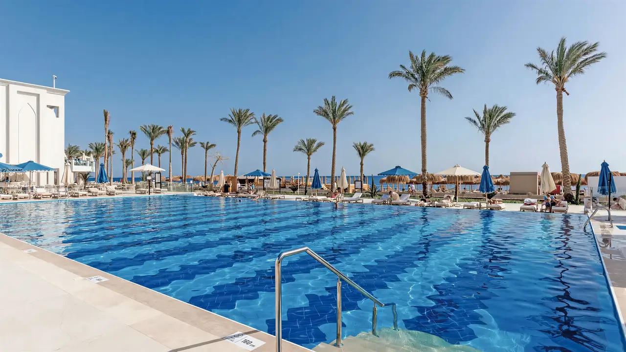Basen z leżakami i palmami w Sunrise Remal Beach