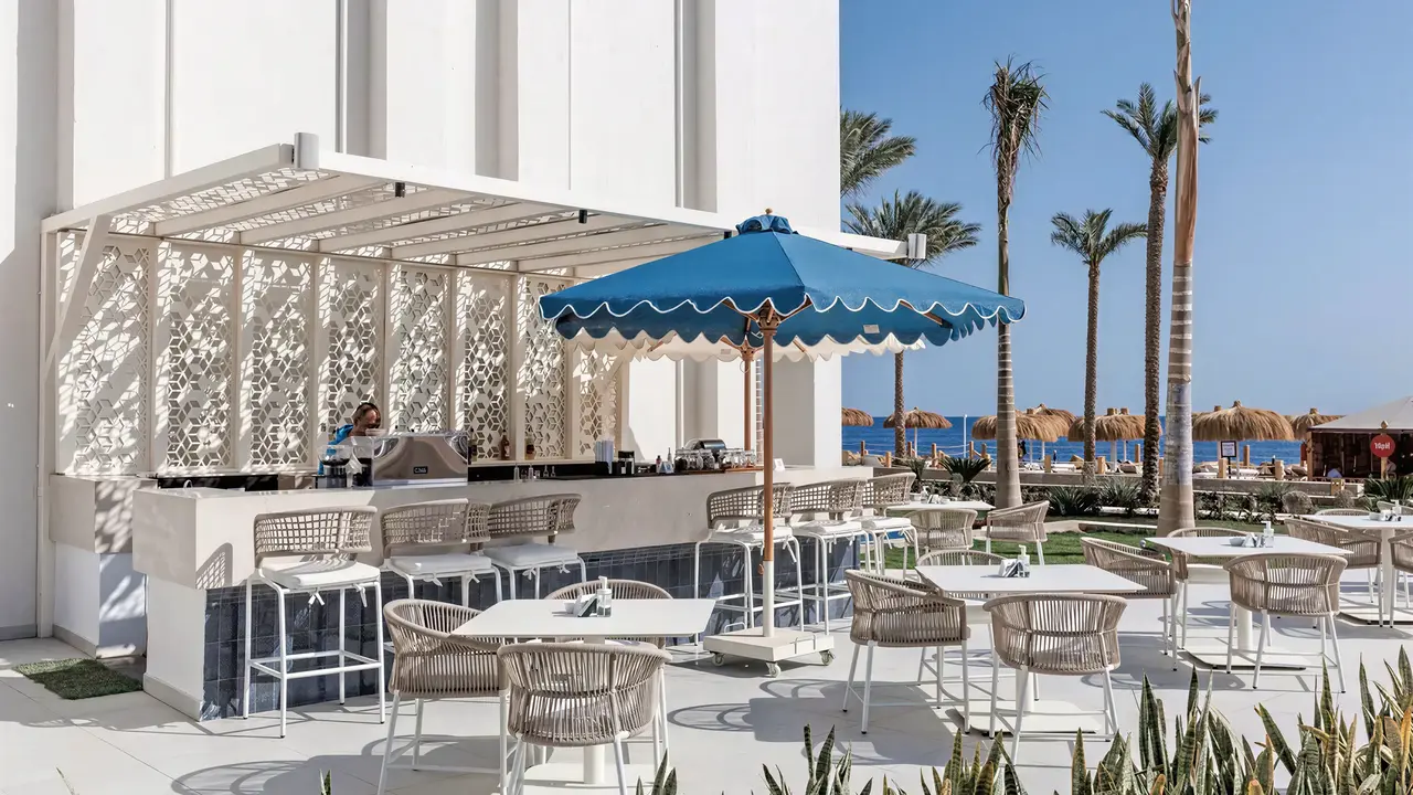 Bar zewnętrzny z białymi stolikami w Sunrise Remal Beach