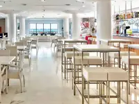 Jasna restauracja w Tahiti Playa z białymi stolikami