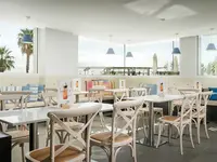 Jasna restauracja z białymi stołami w ThePlace Mar Mediterrania