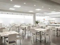 Jasna restauracja w ThePlace Mariner z białymi stołami