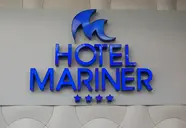 Napis ThePlace Mariner na białej ścianie