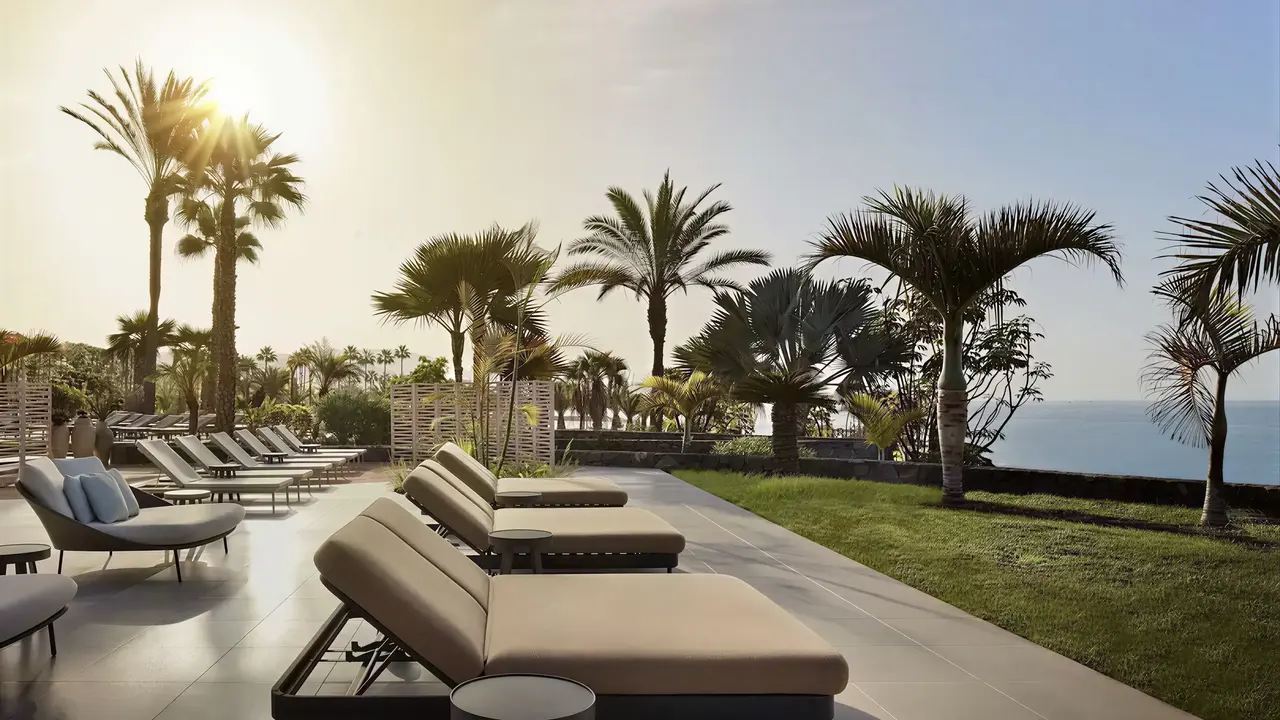 Taras z leżakami i palmami w Tivoli La Caleta Resort