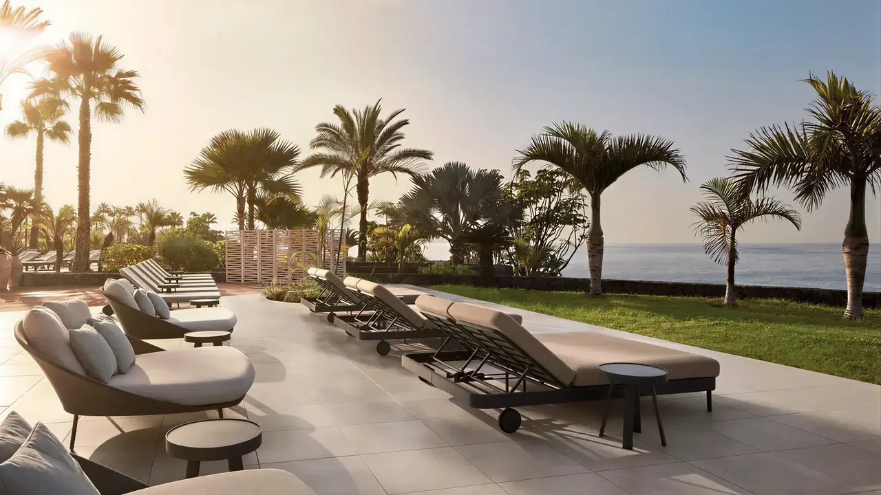 Taras z leżakami i palmami w Tivoli La Caleta Resort
