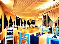 Stolik restauracyjny w Tropitel Dahab Oasis z niebieskimi krzesłami
