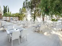 Taras restauracyjny w Utopia Beach Club z białymi meblami