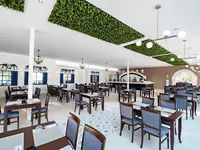 Jasna restauracja w Utopia Beach Club z ustawionymi stolikami