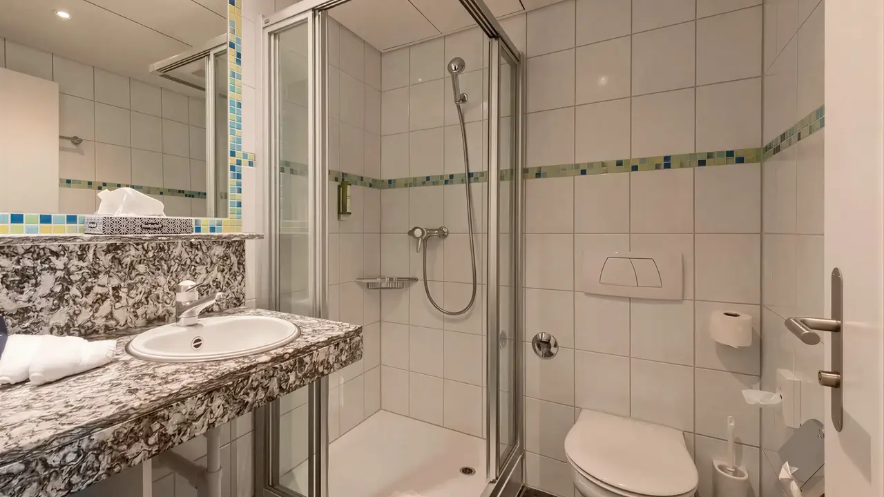 Łazienka w hotelu Victoria Lauberhorn z prysznicem i umywalką