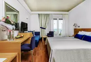 Pokój z łóżkiem i biurkiem w Xenios Anastasia Resort