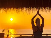 Kobieta ćwicząca jogę o wschodzie słońca w You & Me by Cocoon Maldives