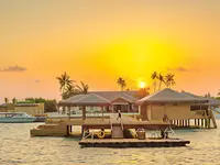 Pawilony nad wodą w You & Me by Cocoon Maldives o zachodzie słońca
